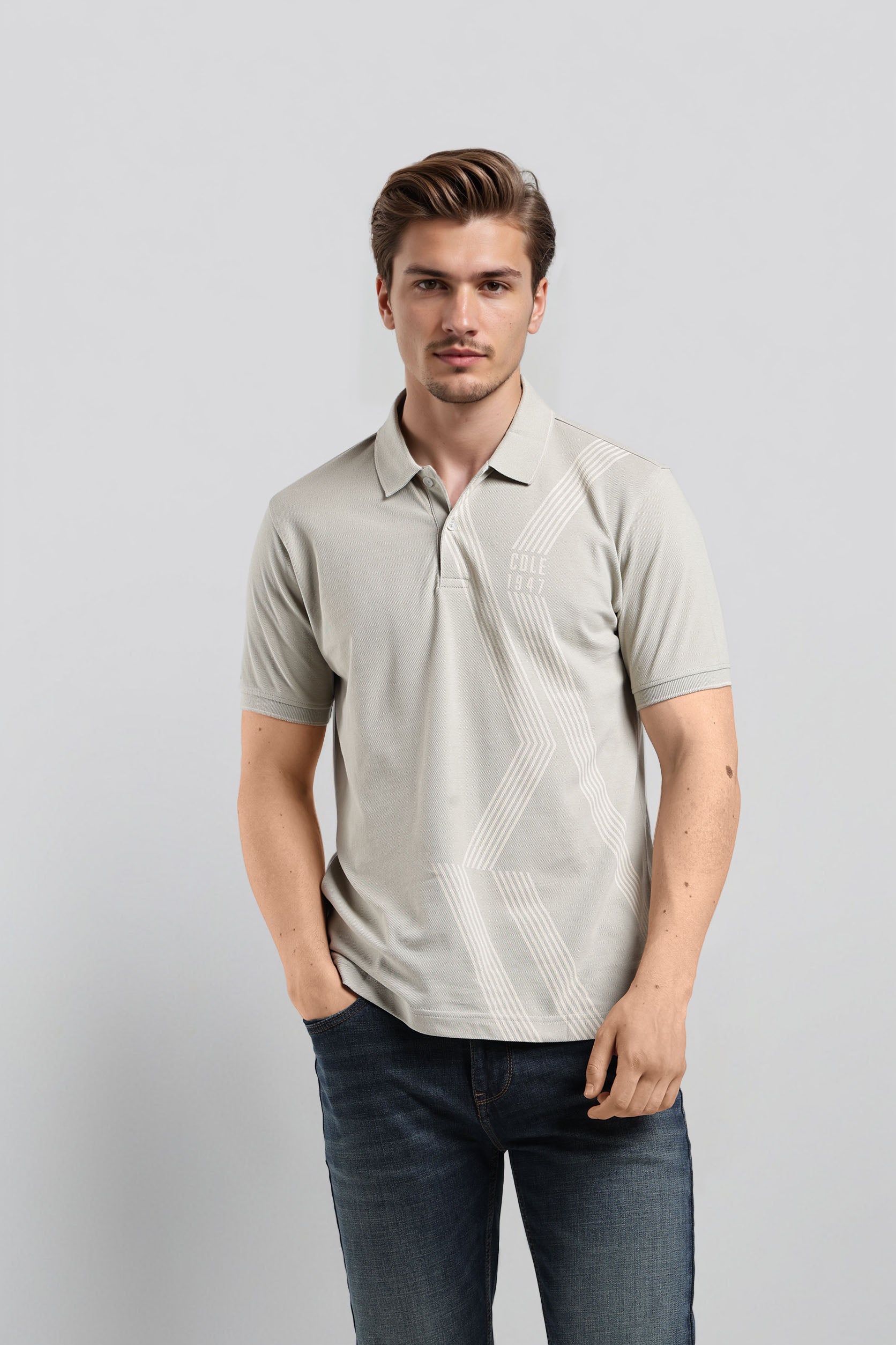 Man wearing a light gray polo shirt with a subtle pattern on a plain background