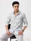 Man wearing a water colour leaf print shirt on a light gray background