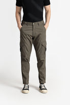 Person wearing olive green cargo pants on a white background