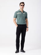 Man wearing a green iceberg green chest print slim fit polo t shirt on a light gray background