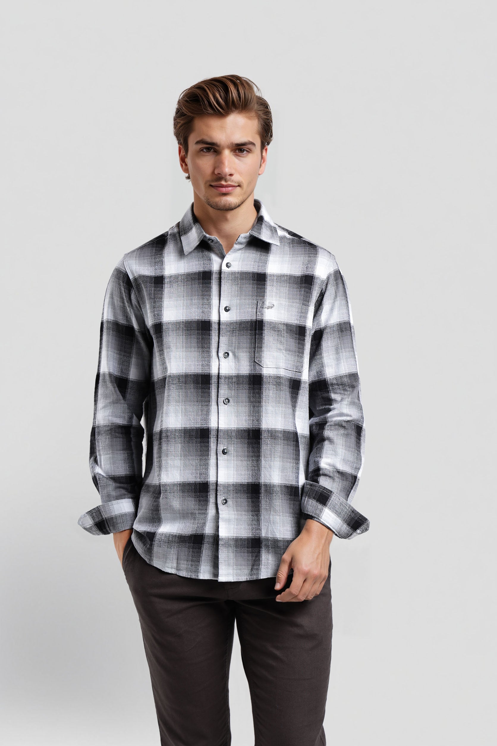 Man wearing a black and white plaid shirt on a light gray background