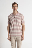 Man wearing a striped polo shirt and beige pants on a white background