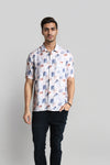 Man wearing a white white fluid shirt abstract print relax fit relaxed fit shirts on a light gray background