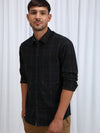 Man wearing a black black checked full sleeve 100% cotton shirt on a light gray background