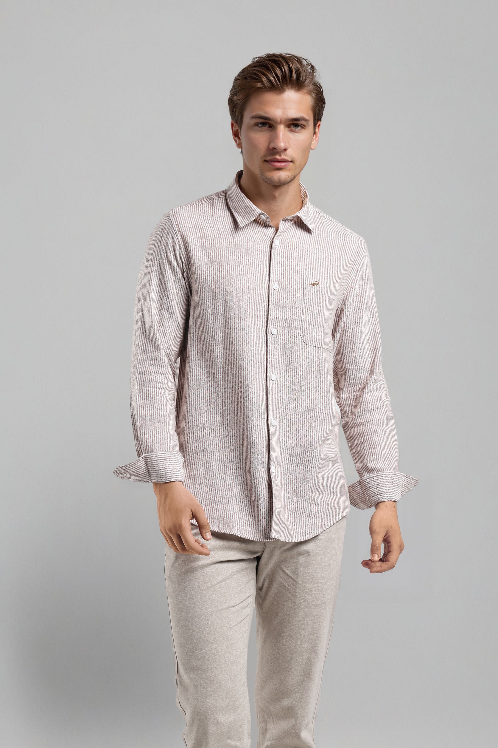 Man wearing a light-colored shirt and pants on a gray background