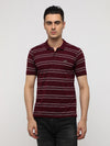 Man wearing a popcorn jaquard striper polo t shirt in maroon on a light gray background