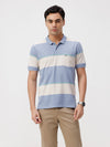 Man wearing a blue grey blue striper comfort fit polo t shirt with casual styling on a gray background