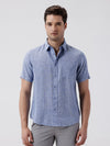 Man wearing a blue premium tensil linen shirt blue on a light gray background