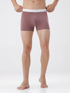 Person wearing mauve boxer briefs with white waistband on a white background