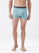 Person wearing light blue boxer briefs with a dark waistband on a white background