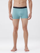 Person wearing light blue boxer briefs with a white background
