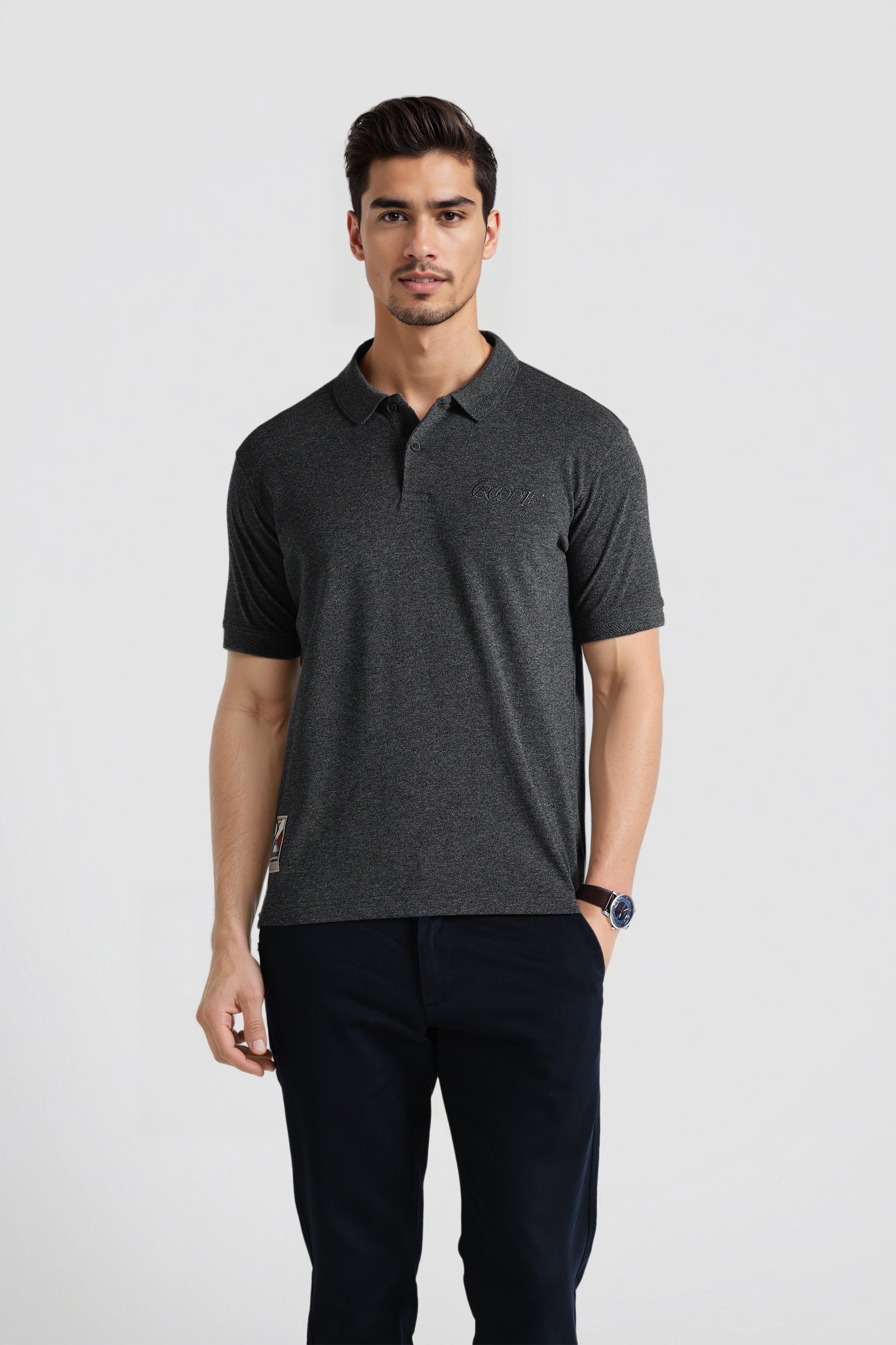 Man wearing a dark gray polo shirt and black pants on a white background