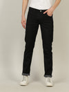 Man wearing a black black solid mid rise slim fit jean with casual styling on a gray background