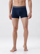 Man wearing navy blue boxer briefs on a white background