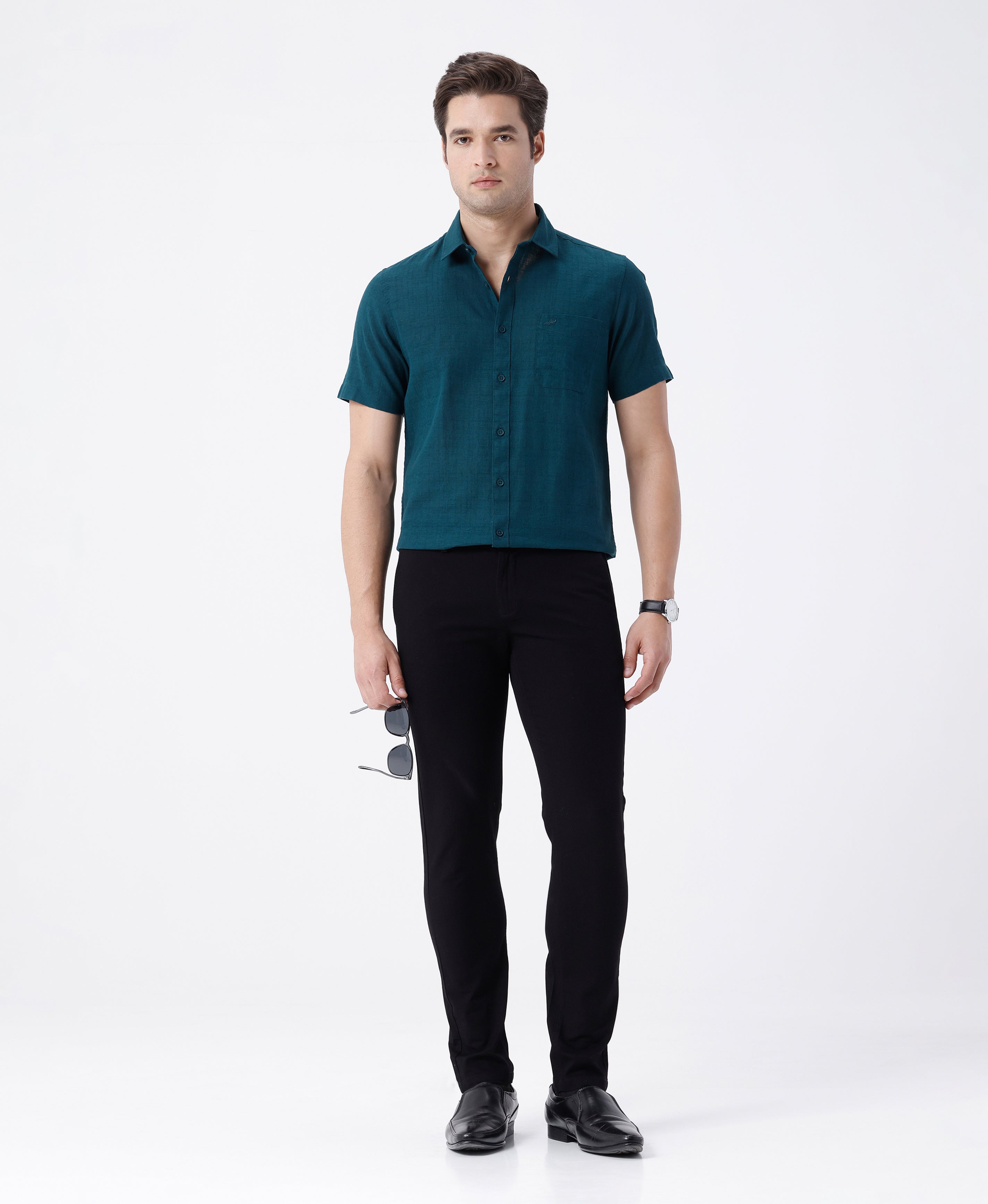 Woman wearing a black textured essential chinos in black on a light gray background