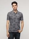 Man wearing a grey floral abstract all over print polo t shirt in grey on a light gray background