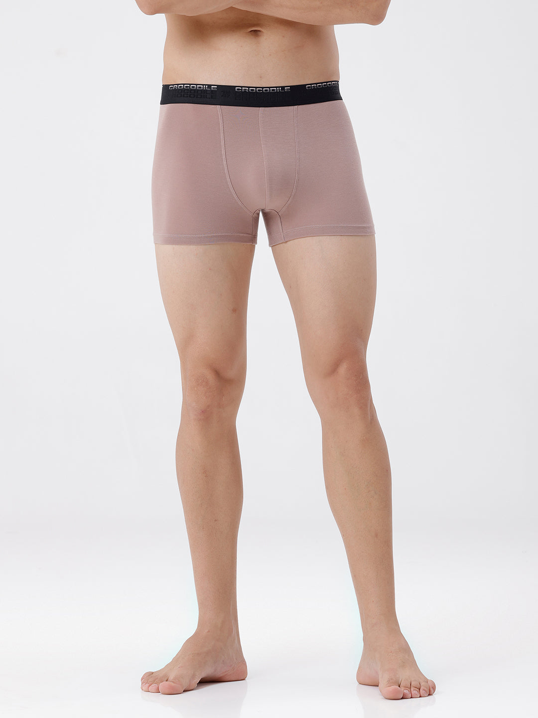 Person wearing a pair of pink boxer briefs with a black waistband on a white background