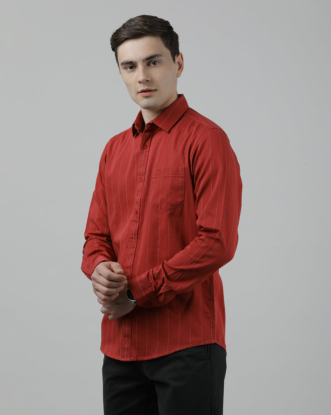 Man wearing a red red striped full sleeve 100% cotton casual shirt on a light gray background