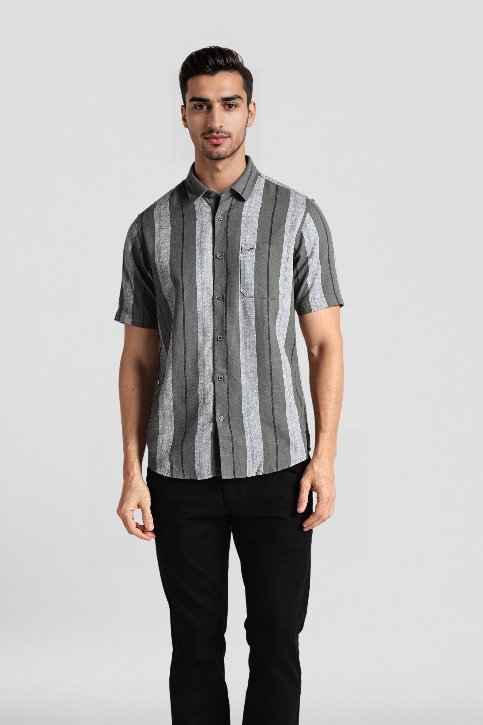 Man wearing a gray and black striped shirt against a plain background