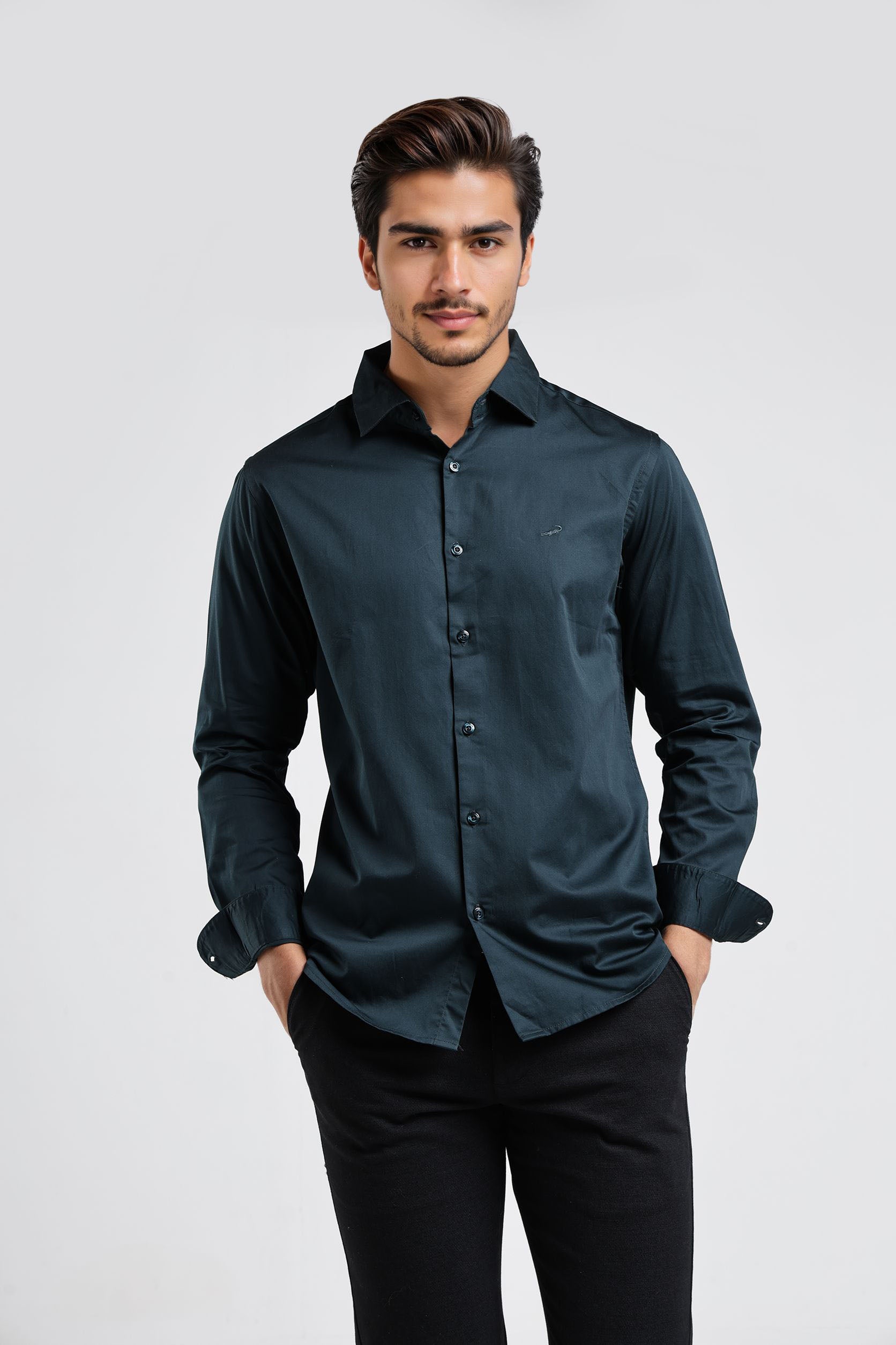 Man wearing a dark green shirt and black pants on a white background