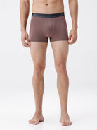 Man wearing brown boxer briefs on a white background