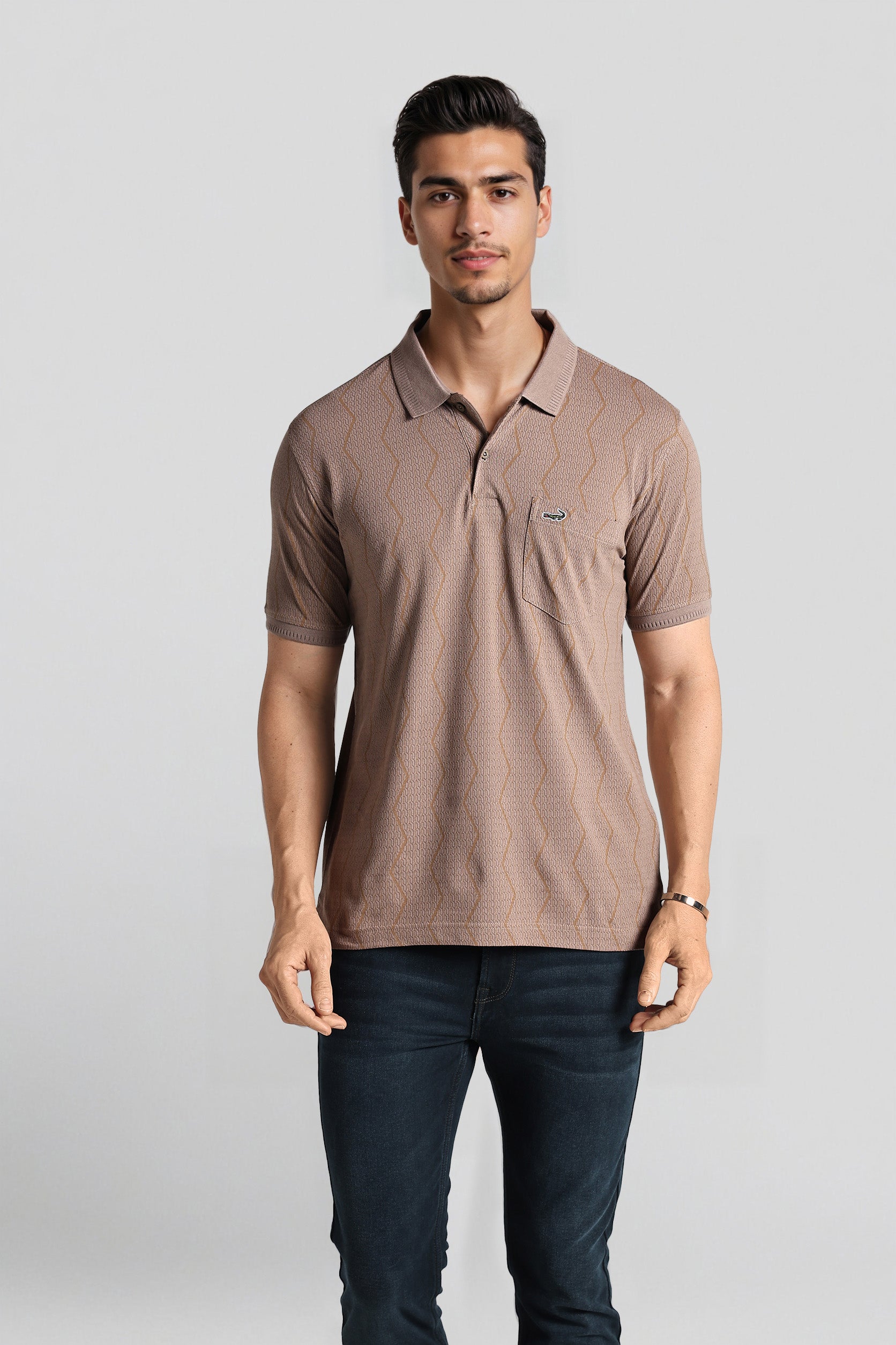 Man wearing a brown polo shirt with a logo on a light gray background