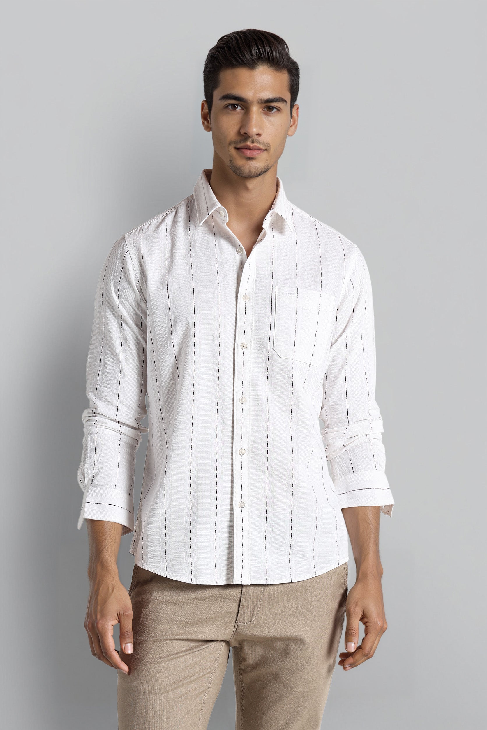 Man wearing a white striped shirt and beige pants against a gray background