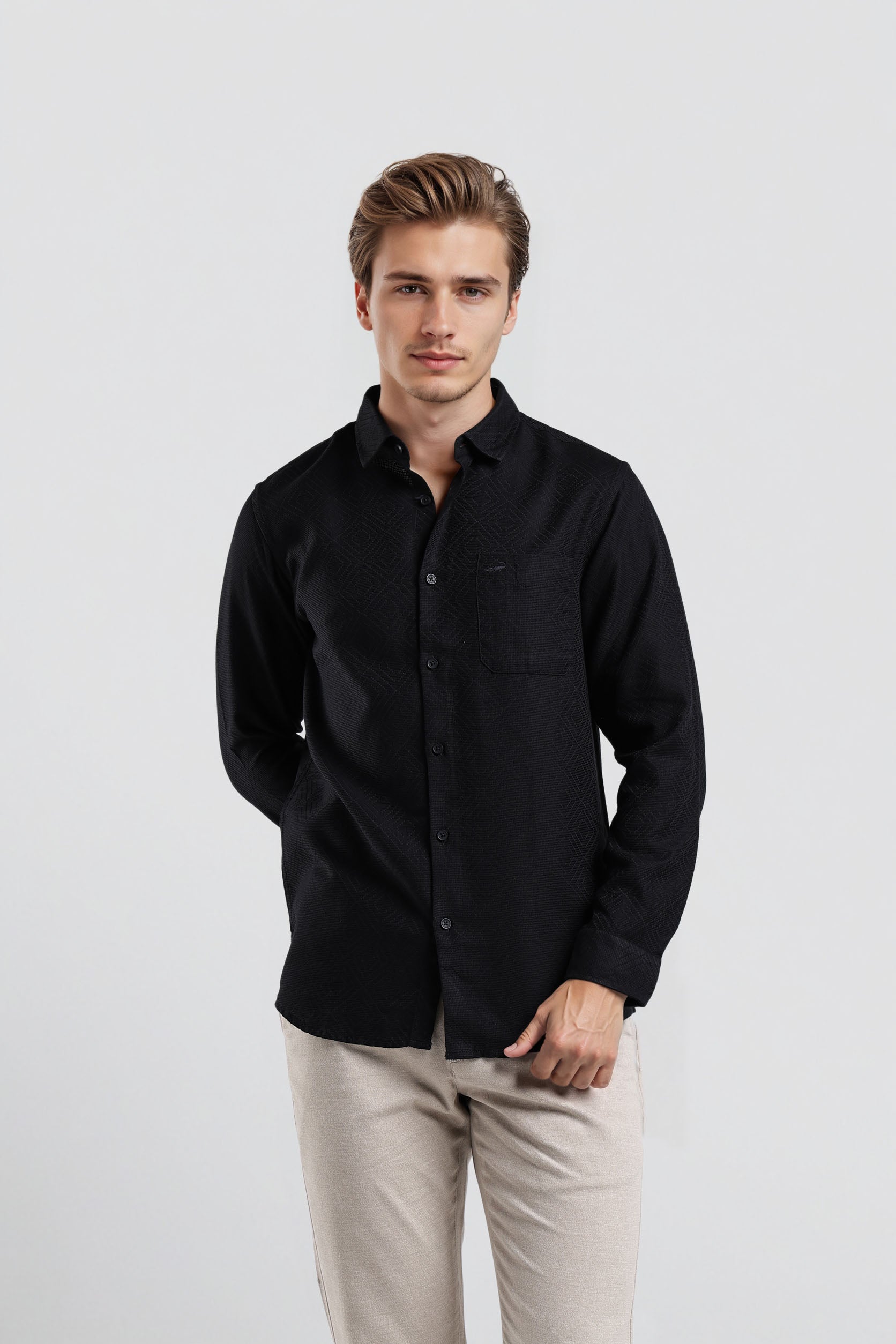 Man wearing a black shirt and beige pants on a white background