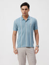 Man wearing a blue blue shadow all over print slim fit polo t shirt on a light gray background