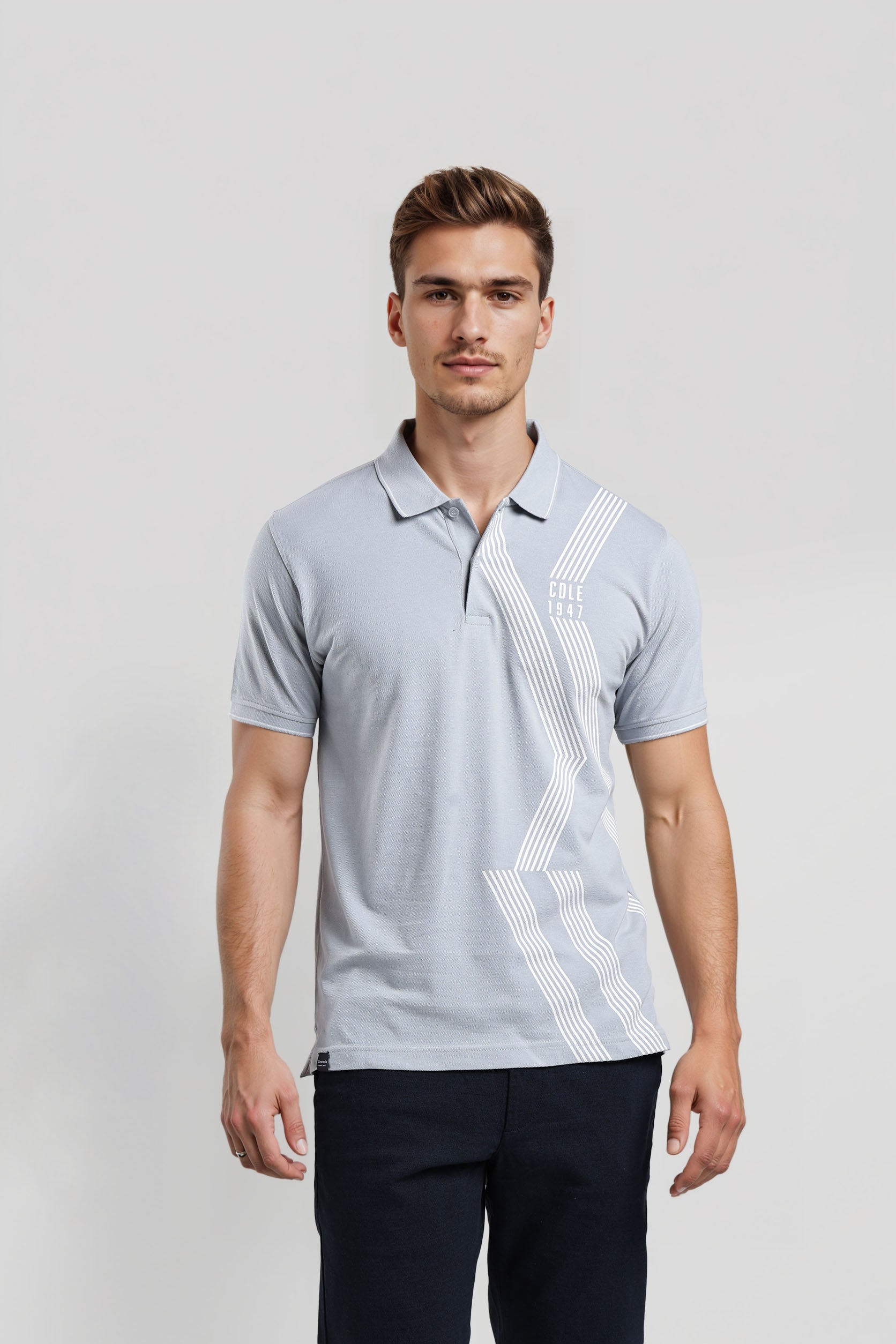 Man wearing a light gray polo shirt with a geometric pattern on a white background