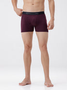 Person wearing maroon boxer briefs with a visible brand logo on a white background