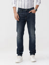Man wearing a blue blue twill slim fit jeans with casual styling on a gray background