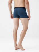 Person wearing a blue boxer brief on a white background