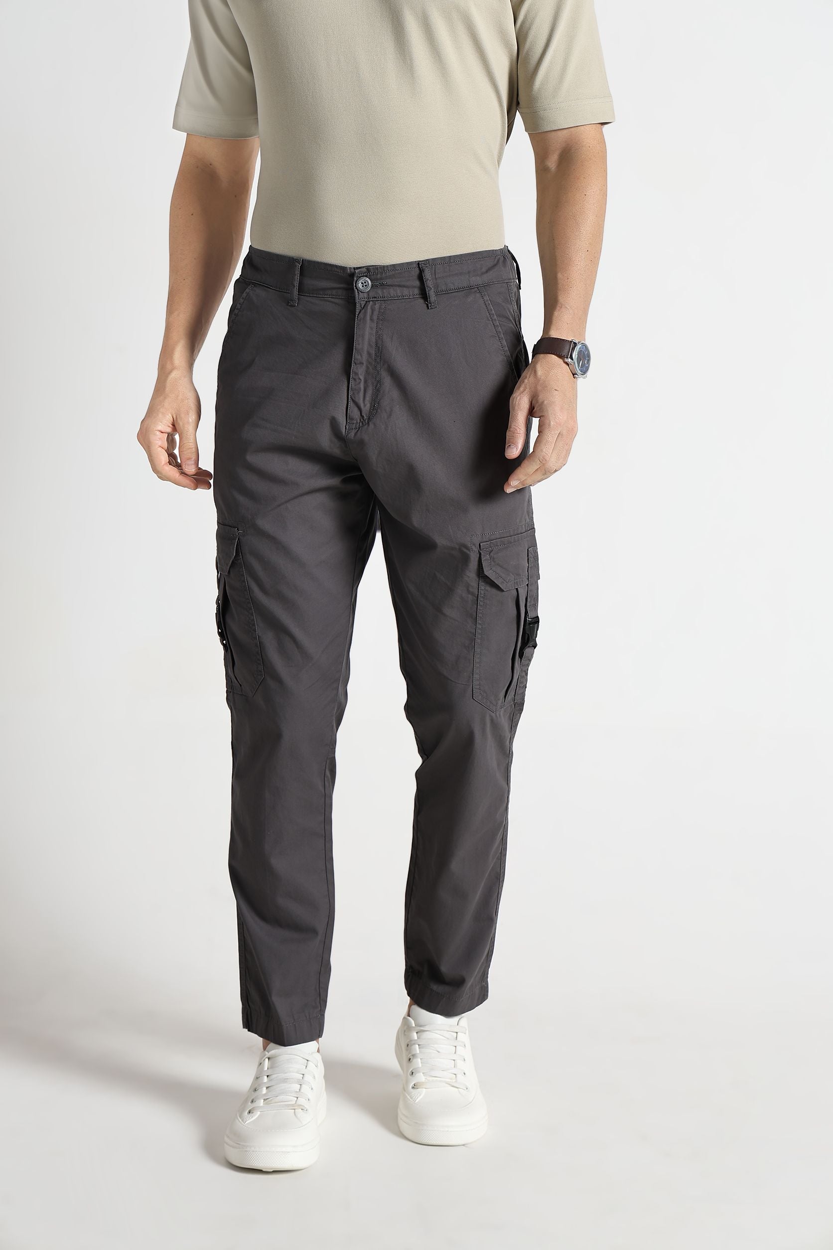 Person wearing gray cargo pants on a white background