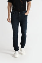 Person wearing black jeans and white sneakers on a white background