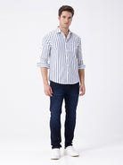 Man wearing a blue dark blue knit slim fit jeans with casual styling on a gray background