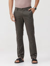 Man wearing a grey dark grey solid slim fit trousers on a light gray background