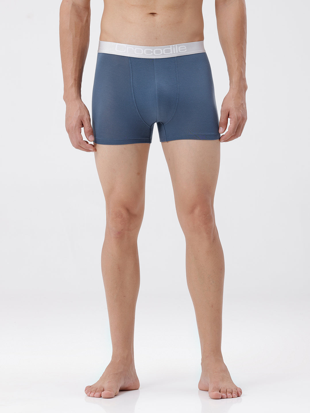 Man wearing blue boxer briefs with white waistband on a white background