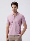 Man wearing a red mercerized subtle textured polo t shirt with casual styling on a gray background