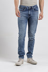 Man wearing a blue blue super stretch fabric cloud washed crocodile slim tappered jeans on a light gray background