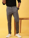 Man wearing a grey casual dark grey solid trouser with casual styling on a gray background