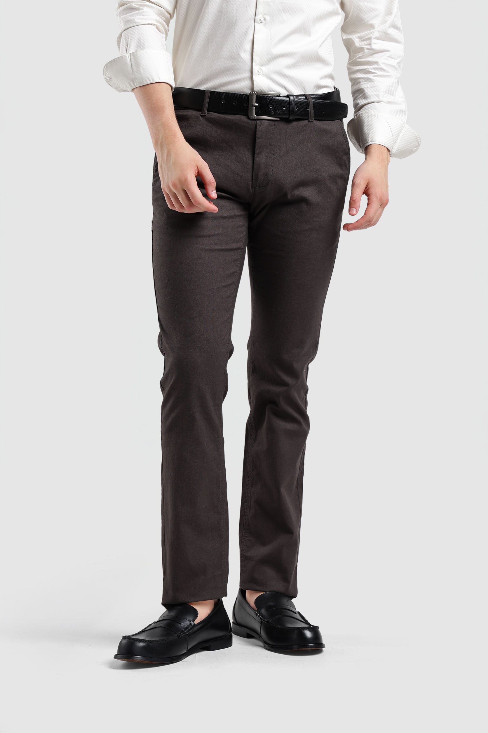 Person wearing a white shirt, dark gray pants, and black shoes on a white background