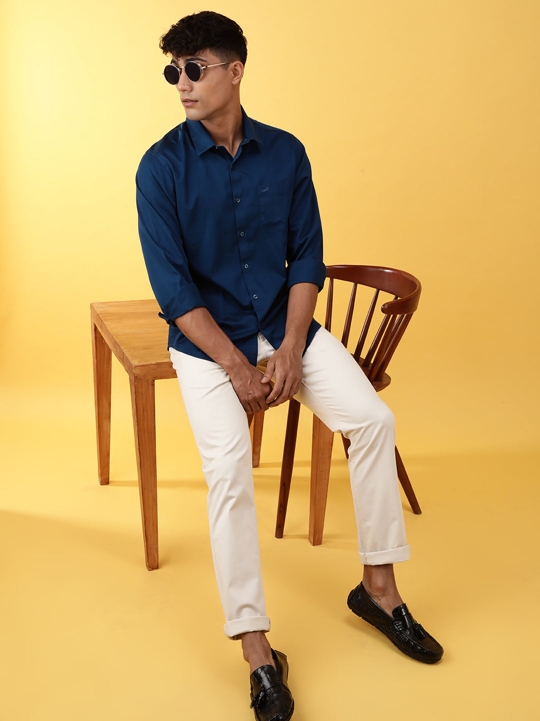 Man wearing a blue royal blue solid full sleeve 100% cotton casual shirt with casual styling on a gray background
