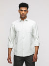 Man wearing a green comfort fit sport green shirt for casual elegance on a light gray background