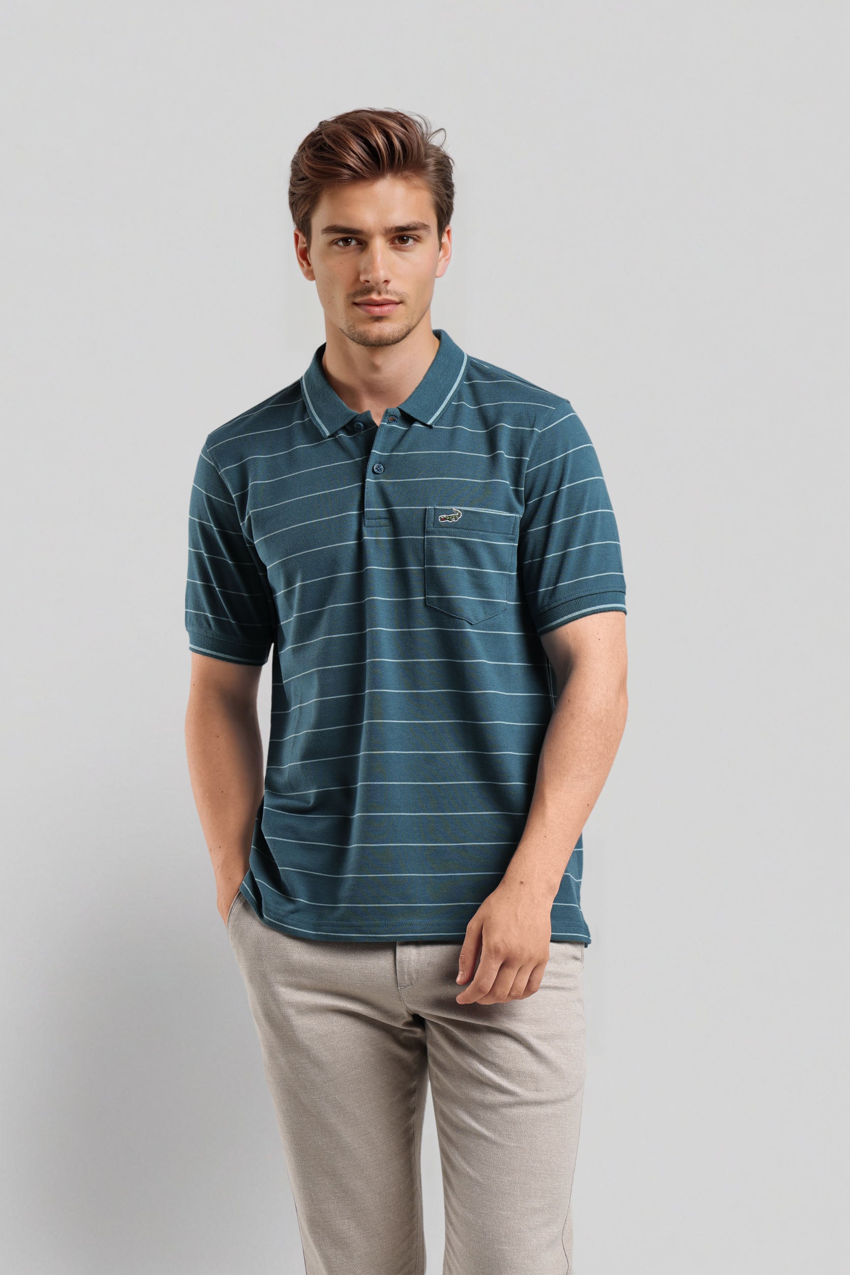 Man wearing a blue striped polo shirt and beige pants on a light gray background