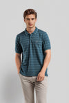 Man wearing a green striper polo t shirt green comfort fit polo t shirt with casual styling on a gray background