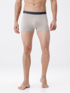 Man wearing beige boxer briefs with a white background