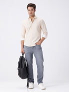 Man wearing a geomentic diamond print shirt on a light gray background