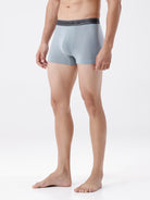 Person wearing light gray boxer briefs on a white background