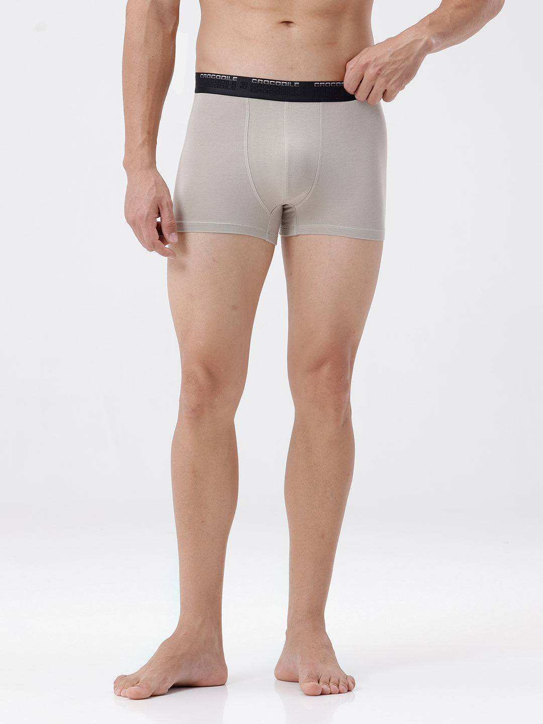 Man wearing beige boxer briefs with black waistband on a white background